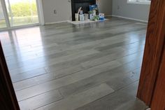 an empty living room with hard wood flooring and sliding glass doors leading to the front door