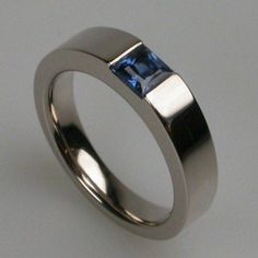 a white gold ring with a blue sapphire stone