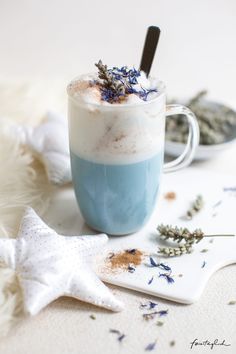 a blue and white drink with lavender sprinkles on it next to a starfish