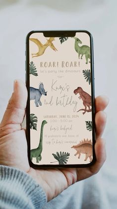 a person holding up a phone with dinosaurs on it