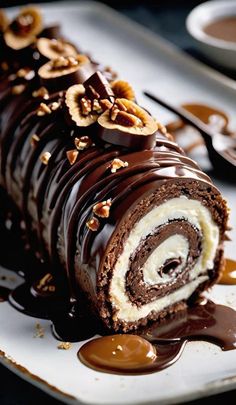 a chocolate roll covered in nuts and drizzled with caramel