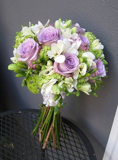 a bouquet of flowers sitting on top of a table next to a cell phone screen