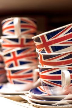 several cups and saucers decorated with the british flag are stacked on top of each other