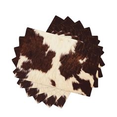 four pieces of brown and white cowhide on top of each other in different sizes