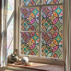 a window with stained glass in the middle and colorful designs on it's side