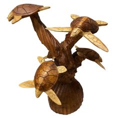 a wooden sculpture with three turtles on it's back