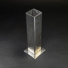 a tall metal object sitting on top of a black surface