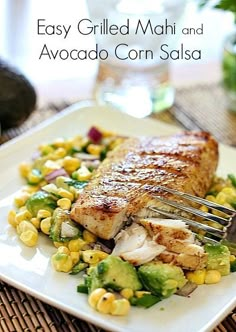 grilled fish and avocado corn salsa on a white plate with a fork