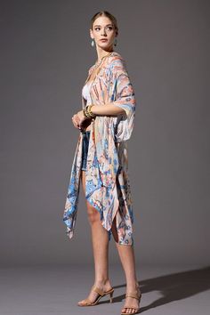 This kimono showcases a floral and Ikat print, with a mid-length style, side slits, and an open front design. Offering a lightweight and soft material, it is essential for summer and can be worn at the lake, beach, or pool as well as a wrap for a casual look. Relaxed, Oversized Fit 1/2 Length Kimono Sleeves Mid-length Side Slits Open Front Bohemian Style One size fits most Length: 38" Width: 40" Summer Patterned Kimono For Beach Cover-up, Spring Flowy Wrap Cover-up, Casual Patterned Kimono For Beach Cover-up, Oversized Spring Cover-up For A Day Out, Printed Kimono Beach Cover-up For Beach Season, Casual Spring Cover-up With Kimono Sleeves, Spring V-neck Beachwear Kimono, Flowy Spring Cover-up With Kimono Sleeves, Summer V-neck One Size Kimono