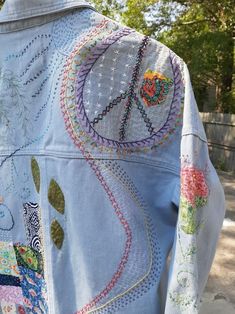 freehand designs of Peace sign, flowers and movement, with Boro inspired sewing bring this vintage jacket back to life. The tag is ' Vintage Demin, by 26 International' and says size large. I designed the patterns and picked the fabrics I thought would be fun in the Boro sections. It has some hand applique flowers on one sleeve and a couple leaves on the back.  I wanted to use different techniques to create this piece. Although I have done this before; this is the first one I have done for sale.  I really like the idea of 'fixing' something you loved, but is a bit forlorn. Less waste , more happy.   I hope this piece goes over well. I do love hand work. Peace Sign Flowers, Natural Embroidery, Sign Flowers, Applique Flowers, Wearable Art Clothing, Vintage Jean Jacket, Love Hand, Diy Skirt, Hand Applique