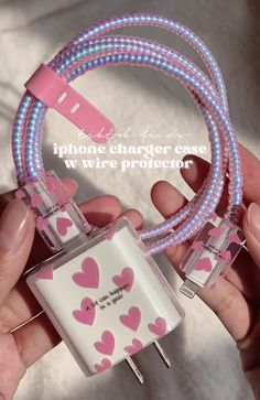 someone is holding an iphone charger with pink hearts on it and two wires connected to each other