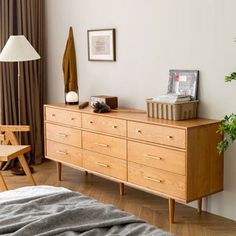 a bedroom with a bed, dresser and chair next to a window in the room