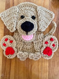 a crocheted dog is sitting on the floor with its tongue out and eyes wide open