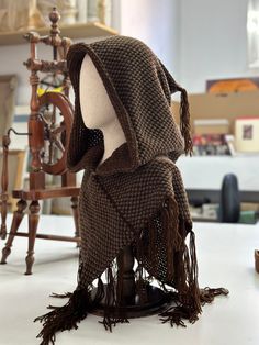 an old fashioned chair with a scarf on it's head and some other things in the background