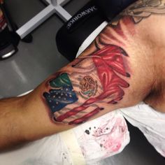 a man's arm with an american flag tattoo on it, and the colors of the united states