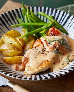 a plate with chicken, potatoes and green beans