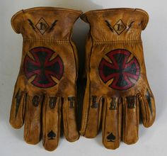 two brown leather gloves with red and black designs on the palm, one worn by a man