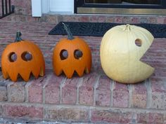 three carved pumpkins sitting on the front steps with their faces cut out to look like jack - o'- lanterns