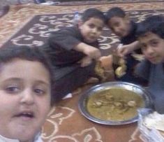 four children sitting on the floor with food in front of them