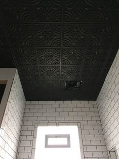 a bathroom with white tile and black ceiling