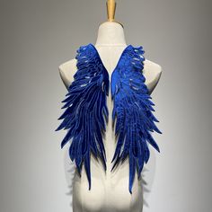 a white mannequin with blue wings on it's chest and back torso