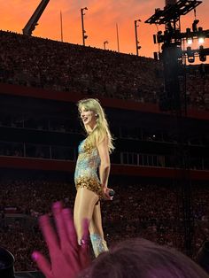 a woman in a bodysuit standing on top of a stage