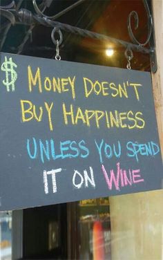 a sign that says money doesn't buy happiness unless you spend it on wine