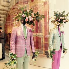 two mannequins dressed in suits with flowers on their heads and one wearing a pink suit