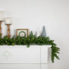 a mantel with candles and christmas decorations on it