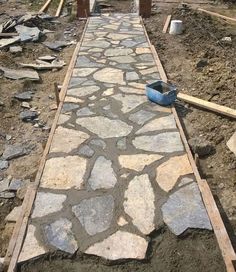 a stone walkway being built in the middle of a yard