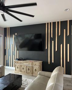 a large flat screen tv mounted to the wall in a living room next to a white couch