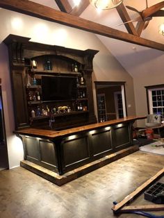 an unfinished bar in the middle of a room with wood flooring and exposed beams