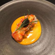 a plate with some food on it in a metal bowl and garnishes