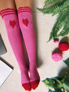 a woman's legs wearing pink socks with red hearts on them and green leaves