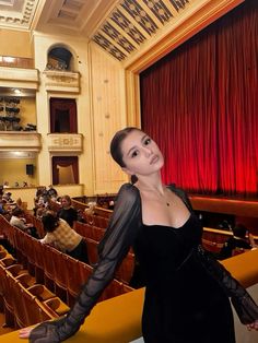 a woman standing in front of an auditorium filled with people