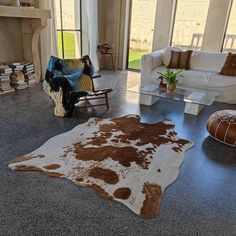 a living room filled with furniture and a cowhide rug