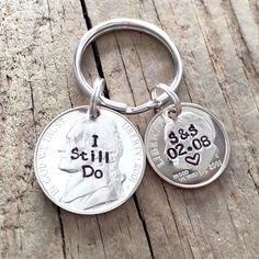 a keychain that has two coins on it and the words i still do