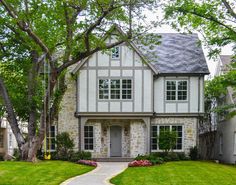 a house with landscaping and trees in the front yard