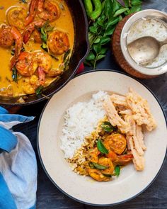 a plate with rice and shrimp next to a pot full of soup on a table