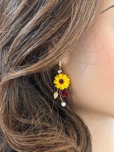 a mannequin head with sunflowers and pearls on it's ear