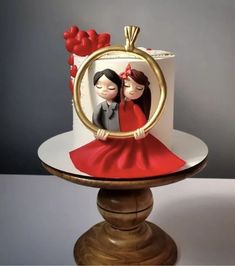 a cake decorated with an image of two people in a frame on top of a wooden stand