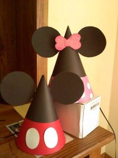 a mickey mouse party hat with a pink bow on it and a minnie mouse cone