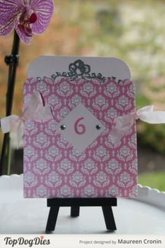 a pink and white card with a number 6 on it sitting on top of a table