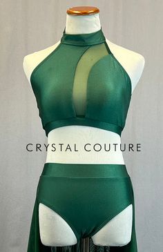 Dark Green mock neck halter top has mesh insert on front of top that curves from left collar bone and down center of sternum. Paired with matching trunks with attached double layer mesh back skirt. *This is a brand new leotard in partnership with Patrick J. We can customize this base to your liking with rhinestones, appliques, skirts, feathers, etc. **Costume in image is an AS, Photographed on an AS/AM Mannequin with Measurements of: Bust 35", Ribcage 30", Waist 25", Hip 34", Girth 57" Elegant Fitted Green Halter Top, Fitted Party Swimwear With Mesh Back, Fitted Green Mesh Top For Party, Fitted Nylon Halter Top For Summer, Fitted High Neck Halter Top, Fitted Green Mesh Top For Summer, Green Fitted Halter Top For Party, Fitted Sheer Swimwear For Club, Neck Halter Top