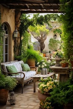 an outdoor sitting area with potted plants and flowers on the patio, along with a bench