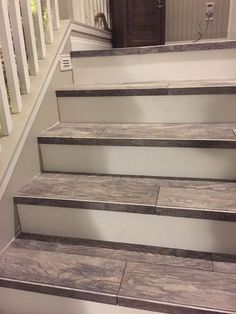 some stairs that have been painted white with wood flooring on the bottom and bottom