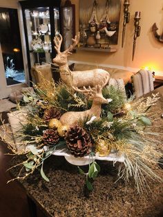 a christmas centerpiece with deer and pine cones