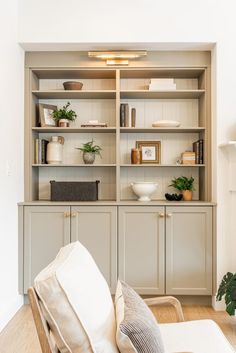 a living room filled with lots of furniture and plants on top of bookshelves