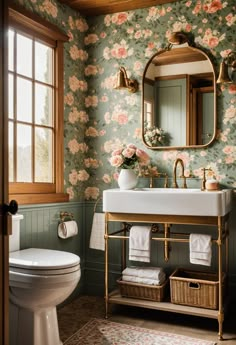 a bathroom with floral wallpaper and gold fixtures