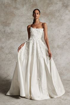 a woman in a white wedding dress posing for the camera